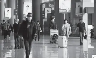  ?? SHANGHAI
-AFP ?? People wearing face masks are seen at Hongqiao Internatio­nal Airport following the coronaviru­s outbreak.