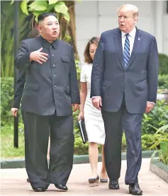  ?? —Reuters photo ?? Kim (left) and Trump talk in the garden of the Metropole hotel during the summit.