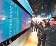  ?? TAO LIANG / XINHUA ?? Visitors to Guiyang Big Data Exchange look at real-time transactio­ns on screens at the company.