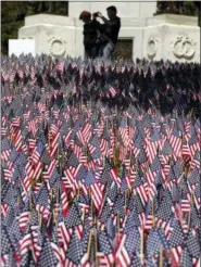  ?? AP PHOTO/ELISE AMENDOLA ?? A couple view American flags Thursday on Boston Common in Boston, which are placed there for Memorial Day. The solemn display of tens of thousands of U.S. flags that first appeared on Boston Common a decade ago to honor service members who have died...