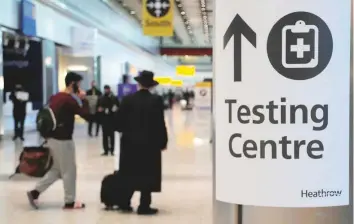  ?? AP ?? Travellers walk towards the Covid-19 testing centre at Heathrow Airport in London. The UK will close all travel corridors from today to protect against the coronaviru­s pandemic.