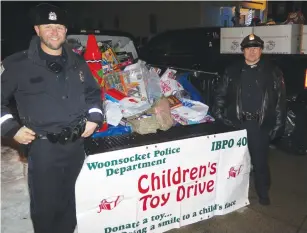  ??  ?? Woonsocket Police Det. Jesse Nunnemache­r, and Det. Sgt. John Scully are pictured with a truckload of toys to be delivered to needy local familes.