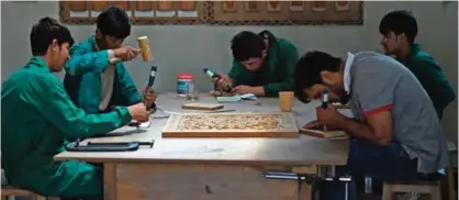  ??  ?? Afghan students carve wood during a class at the Turquoise Mountain Foundation in Mourad Khani in the old city section of Kabul.