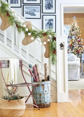  ??  ?? [LEFT] WRAP IT UP. Even a wrapping station can be decorative and functional when made into a vignette. Julie corralled rolls of wrapping paper into an antique water bucket. “I have a weakness for French bistro chairs, and recently found a weathered red one, which works perfectly as part of this holiday spot,” says Julie.