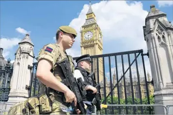  ?? JUSTIN TALLIS/GETTY-AFP ?? A soldier and police officer patrolWedn­esday in London. The country will observe a moment of silence Thursday.