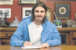  ??  ?? Jon Aurtenetxe signs his extended contract at Dens Park yesterday.