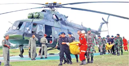  ??  ?? Indonesian soldiers and police officers carry the bodies of victims of a massacre by suspected separatist rebels in Timika, Papua province. — AFP photo