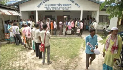  ?? AP ?? People whose name were left out in the National Register of Citizens draft stand in a queue to collect forms in Mayong. —