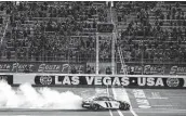  ?? Chris Graythen / Getty Images ?? Denny Hamlin celebrates with a burnout after getting his first career victory at Las Vegas Motor Speedway.