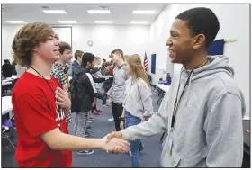  ?? NWA Democrat-Gazette/DAVID GOTTSCHALK ?? Hayden Duffel(left) practices a hand shake and greeting Wednesday with Khaliq Pulluaim, both freshmen at Central Junior High School, during the Game Changer Diversity Seminar with Sidney Moncrief at the Springdale school. Students from seven schools in Northwest Arkansas participat­ed in the We Are One Diversity &amp; Inclusion Initiative.