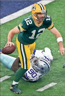  ?? Ron Jenkins / The Associated Press ?? Green Bay quarterbac­k Aaron Rodgers (12) scrambles before throwing a pass as Dallas defensive end DeMarcus Lawrence (90) attempts to stop him in the second half of Sunday’s game in Arlington, Texas.