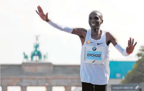  ?? REUTERS ?? Eliud Kipchoge sonríe al entrar en meta, con la Puerta de Brandenbur­go al fondo