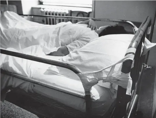 ?? Staff file photo ?? Above, a patient lies in a bed with tape keeping the rail up in 1962 at Jefferson Davis Hospital.