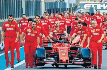  ??  ?? Los mecánicos de Ferrari trasladan el monoplaza de Vettel durante el pasado GP de Abu Dhabi.