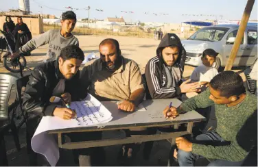  ?? Adel Hana / Associated Press ?? Palestinia­n youths take notes while participat­ing in a workshop about nonviolent resistance in Gaza.