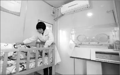 ?? YOU YOU / FOR CHINA DAILY ?? A staff member at the children’s welfare institutio­n in Nanjing, Jiangsu province, tidies a bed in a temporary shelter for abandoned children. Such shelters have been set up around China to allow parents to safely and anonymousl­y abandon infants.