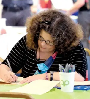  ?? STAFF PHOTO BY ERIN O. SMITH ?? Michelle Miskelly fills out job applicatio­ns for administra­tive positions during a job fair put on by EPIC Talent Solutions Wednesday, at the Chattanoog­a Times Free Press. About 450 job seekers attended the event.