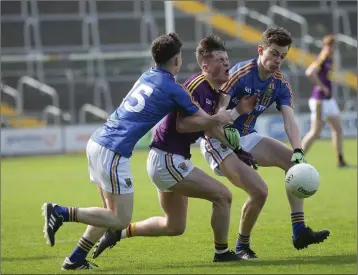  ??  ?? Wexford’s Jamie Meyler is tackled by Wicklow’s Mark Reid and Kieran Sheehy.