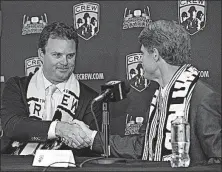  ??  ?? Anthony Precourt, left, shakes hands with Clark Hunt after acquiring the Crew from the Hunt Sports Group in July 2013.