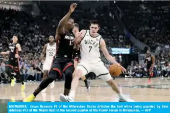  ??  ?? MILWAUKEE: Ersan Ilyasova #7 of the Milwaukee Bucks dribbles the ball while being guarded by Bam Adebayo #13 of the Miami Heat in the second quarter at the Fiserv Forum in Milwaukee, — AFP