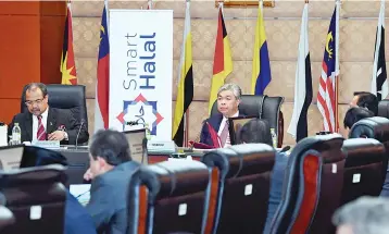  ?? — Bernama photo ?? Ahmad Zahid (middle) chairs the Malaysia Halal Council meeting yesterday. Also seen is Minister in the Prime Minister’s Department Datuk Seri Jamil Khir Baharom (left).