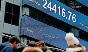  ?? [AP PHOTO] ?? A display shows financial indices in Times Square on Tuesday.