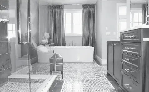  ??  ?? The master ensuite features a beautiful blue and white
tiled floor, stand-alone tub and walk-in shower. The spa-like amenities will make everyday grooming
an absolute pleasure.