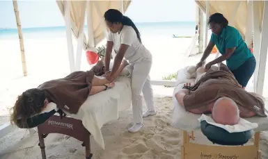  ??  ?? A Tropical Touch massage in progress, soothing muscles on the shore of Negril’s famous seven-mile beach.