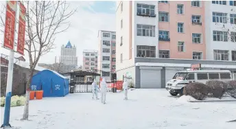  ?? — AFP photo ?? Health workers (centre) in personal protective equipment (PPE) standing guard outside a residental area which is restricted due to the spread of Covid-19 in Manzhouli in China’s northern Inner Mongolia region.