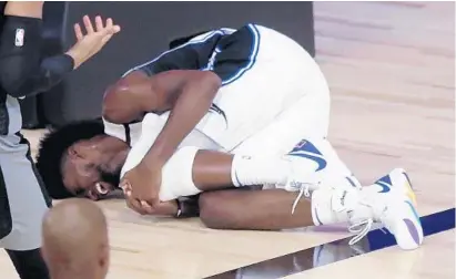  ?? CHARLES KING/ORLANDO SENTINEL ?? Magic forward Jonathan Isaac lays on the court holding his left knee after falling during a play in the fourth quarter of Orlando’s Aug. 2 game against Sacramento at ESPN Wide World of Sports’ HP Field House.