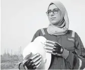  ?? NABIL AL-JOURANI/AP ?? Zainab Amjad stands near an oil field outside Basra. She has bypassed the typical office jobs often given to female petrochemi­cal engineers in Iraq.