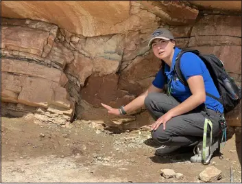  ?? PROVIDED BY DINOSAUR RIDGE ?? Dinosaur Ridge has a number of young staffers, including Education and Camp Coordinato­r Amanda Rea, who is seen here pointing out a dip in the rock layer where a large dinosaur stepped and caused a bulge in what had been soft mud.
