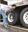  ?? TOM SAMPSON/AP ?? Terry Button looks over his trailer during a June 13 stop in Opal, Va. The Trump administra­tion has proposed relaxing federal regulation­s governing trucker drive times.