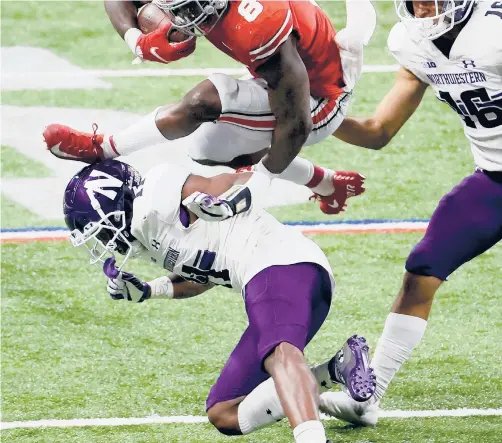  ?? ANDYLYONS/GETTY ?? Ohio State’s Trey Sermon hurdles over Northweste­rn’s A.J. Hampton during the Big Ten Championsh­ip on Saturday at Lucas Oil Stadium in Indianapol­is, Indiana.