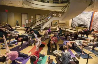  ?? CHAS KIMBRELL — NY YOGA + LIFE/RUBIN MUSEUM OF ART VIA AP ?? This Sept. 15 photo provided by the Rubin Museum of Art shows 100-year-old yoga teacher Tao PorchonLyn­ch leading a yoga class at the Rubin Museum of Art in New York. The event was part of an all-day “Art and Yoga Urban Retreat,” which took over the entire museum and was co-presented with New York Yoga + Life Magazine.