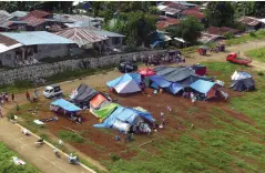  ??  ?? IN MAKILALA town, North Cotabato, residents setup temporary shelters, for fear of more damaging aftershock­s.
BING GONZALES