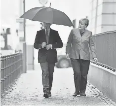  ?? AP ?? German Chancellor Angela Merkel and her husband, Joachim Sauer, arrive to cast their votes in Berlin on Sept. 24.