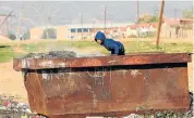  ?? Pictures: ESA ALEXANDER ?? DESPERATE: A young boy forages in a rubbish skip in Bongolethu township, Oudtshoorn