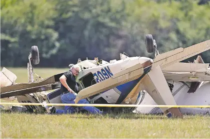  ??  ?? An investigat­or looks at the debris of a plane crash at West Georgia Regional Airport in Carrollton, Ga., on Wednesday.