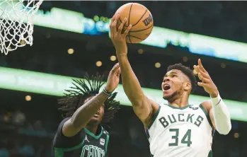  ?? ADAM GLANZMAN/GETTY ?? Giannis Antetokoun­mpo of the Milwaukee Bucks drives to the basket past Robert Williams III of the Boston Celtics during Game 1 of the Eastern Conference Semifinals on Sunday.