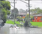  ?? ?? A car is seen submerged in floodwater­s in the residentia­l area of the southweste­rn suburb of Sydney on Tuesday.