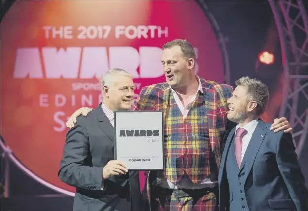  ??  ?? Doddie Weir receives his award from Scott Hastings, left, watched by event host and Radio Forth DJ Boogie at the Usher Hall in Edinburgh yesterday
PICTURE: IAN GEORGESON