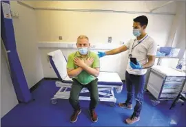  ?? Kirsty Wiggleswor­th Associated Press ?? GARY MILLER, left, a long COVID patient, receives treatment from physiother­apist Joan Del Arco at a clinic at King George Hospital in London in May 2021.