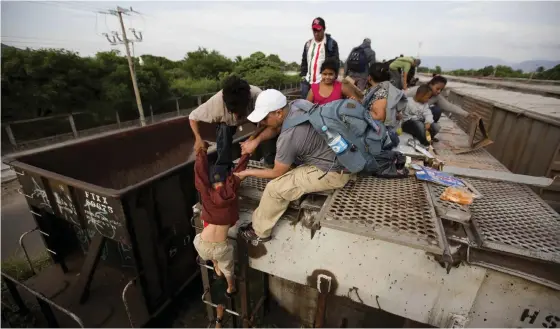  ?? FOTO: EDUARDO VERDUGO/TT-AP ?? La bestia – godståget genom Mexiko som för många migranter är det enda – och livsfarlig­a – sättet att ta sig norröver mot gränsen till USA. Migrantern­a sitter på vagnstaken och måste hoppa på i farten. Stationern­a är inhägnade – just för att stoppa fripassage­rarna.