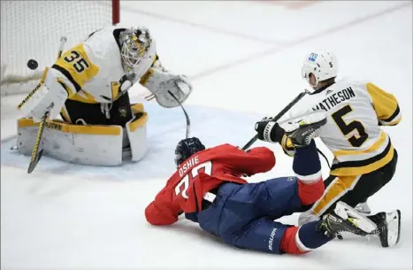  ?? Associated Press ?? Despite falling to the ice, Washington’s T.J. Oshie manages to score on Tristan Jarry Thursday night for a 2-0 Capitals lead.