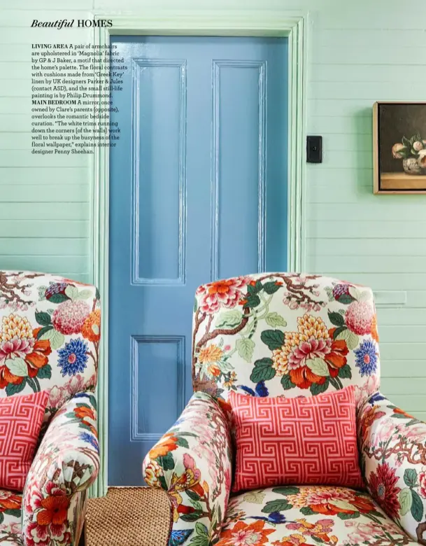  ?? ?? LIVING AREA A pair of armchairs are upholstere­d in ‘Magnolia’ fabric by GP & J Baker, a motif that directed the home’s palette. The floral contrasts with cushions made from ‘Greek Key’ linen by UK designers Parker & Jules (contact ASD), and the small still-life painting is by Philip Drummond.
MAIN BEDROOM A mirror, once owned by Clare’s parents (opposite), overlooks the romantic bedside curation. “The white trims running down the corners [of the walls] work well to break up the busyness of the floral wallpaper,” explains interior designer Penny Sheehan.