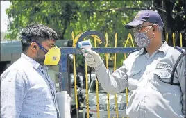  ??  ?? ■
A security personnel uses an infrared thermomete­r to check the temperatur­e of a man at the entrance gate of the municipal corporatio­n office in Gurugram on Tuesday. PARVEEN KUMAR/HT