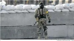  ?? ZURAB KURTSIKIDZ­E / EFE ?? Un soldado ucraniano hace guardia en una barricada ayer en Kiev.