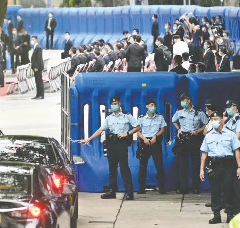  ?? ANTHONY WALLACE / AFP VIA GETTY IMAGES ?? Guests drive past the Office for Safeguardi­ng National Security of the Central People’s Government in Hong Kong after its inaugurati­on on Wednesday. The new office allows Chinese security agents to operate in the former British colony.