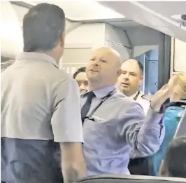  ??  ?? ‘HIT ME!’ An American Airlines employee faces off with a passenger who had left his seat to defend a sobbing mother (right). The woman, who had earlier clashed with the employee, was escorted off the jet (top right).